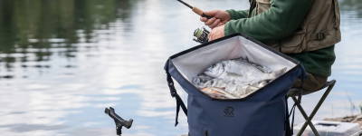 A father is fishing with Rivonova roll-top backpack cooler 35L