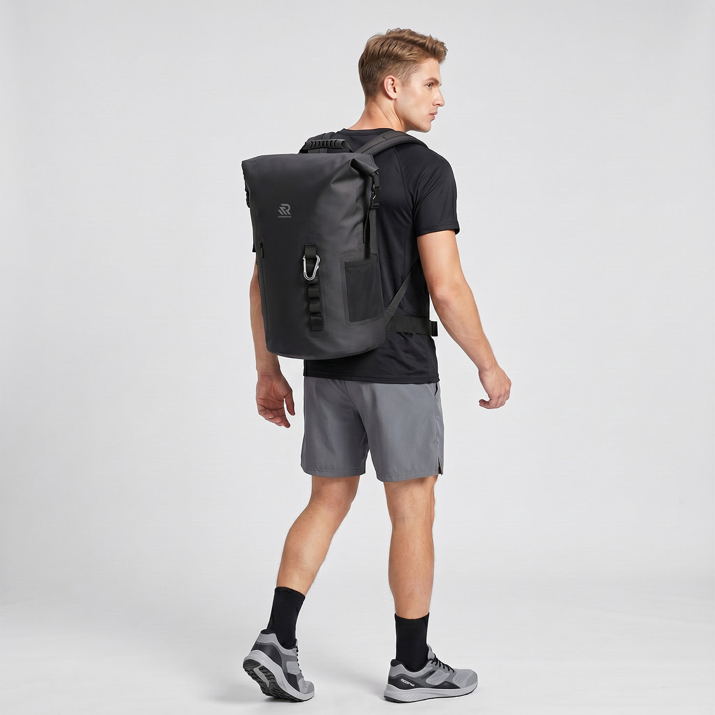 Back view of a man wearing a Rivonova roll-top backpack cooler black