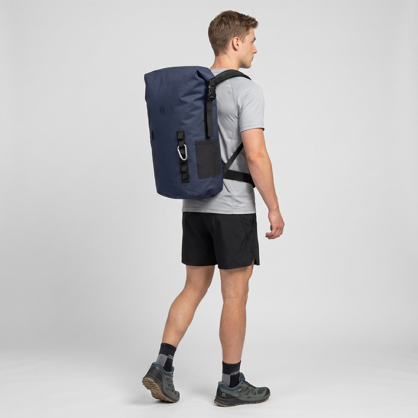 Back view of a man wearing a Rivonova roll-top backpack cooler navy
