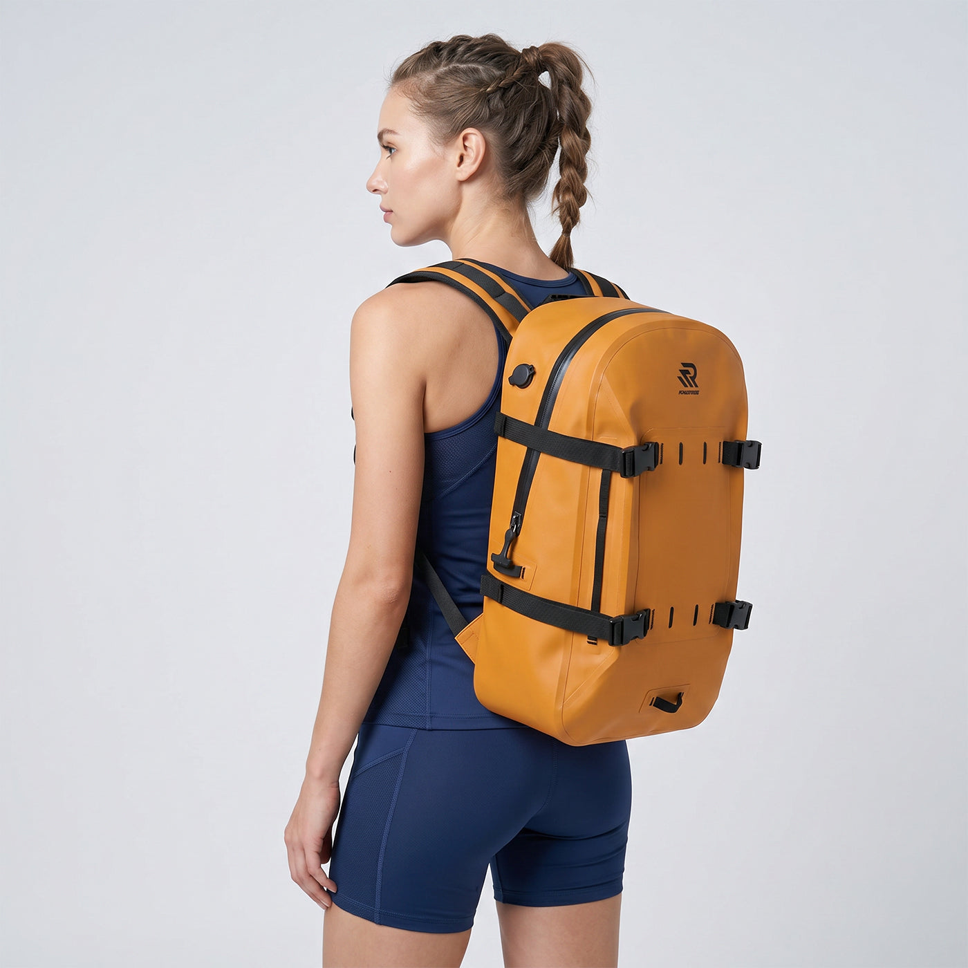 Back view of a woman wearing a Rivonova waterproof backpack cooler orange