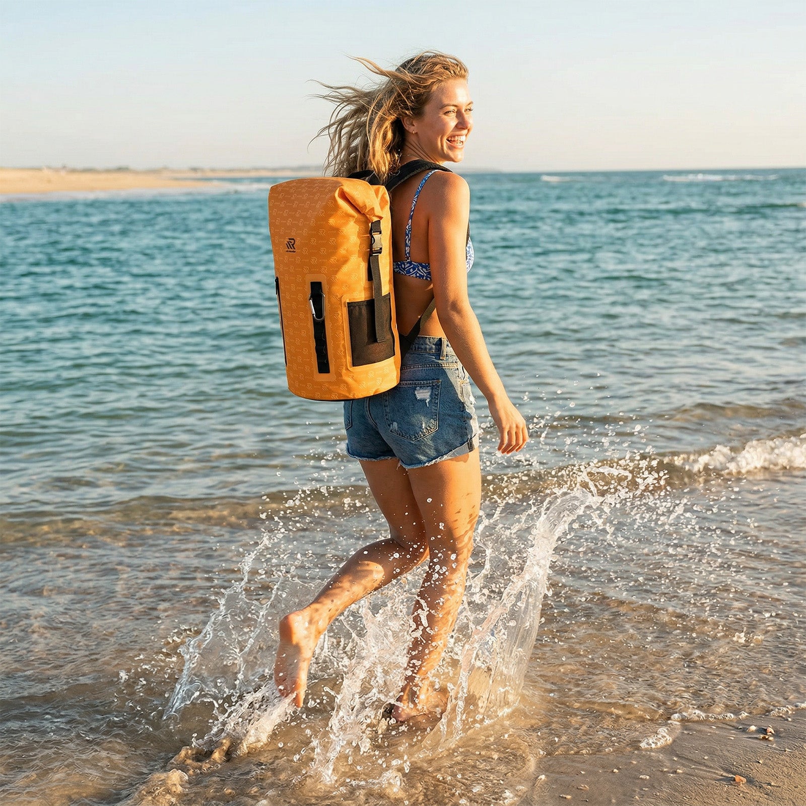 Woman walking along the beach with a Roll-Top Backpack Cooler